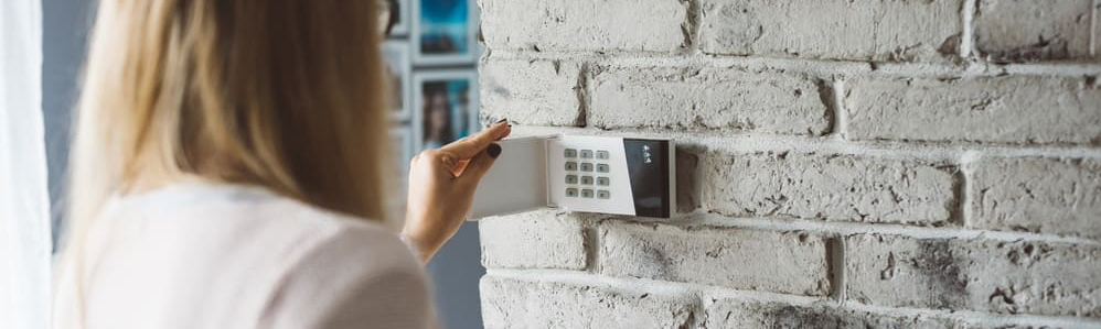 femme ouvrant un bloc d'alarme à code fin de vérifier de mettre l'alarme en fonctionnement